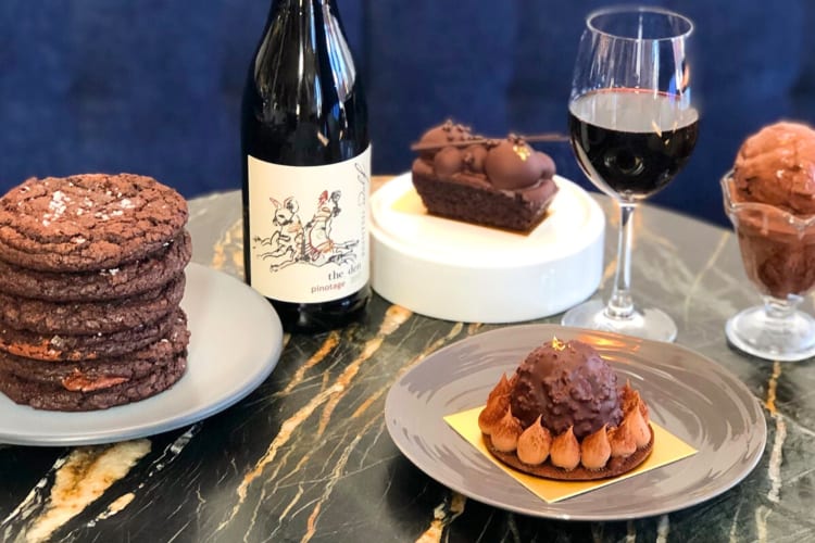 A selection of chocolate desserts and red wine on a table