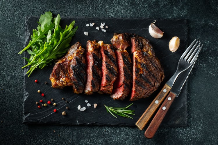 sliced beef with fork and serrated knife