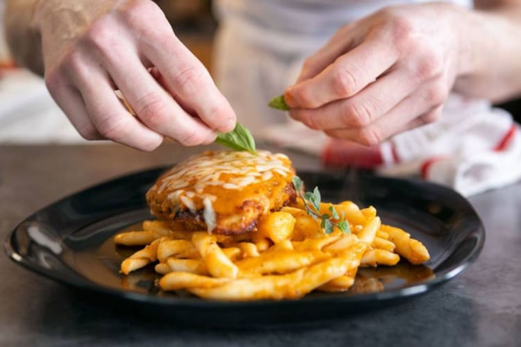 a chef preparing a burger and fries