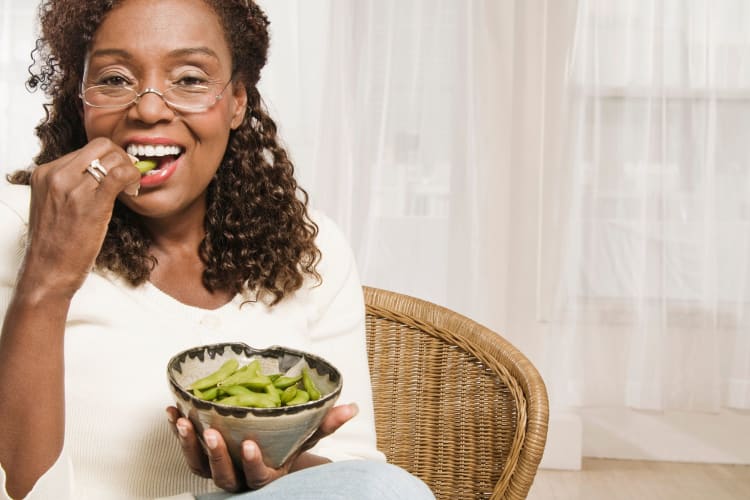 senior woman eating edamame