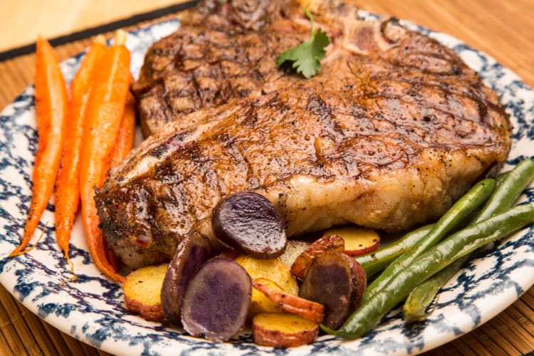 Serve porterhouse and T-bone steaks with vegetables.