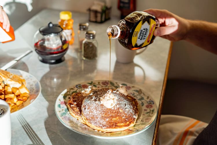 maple syrup poured on pancakes