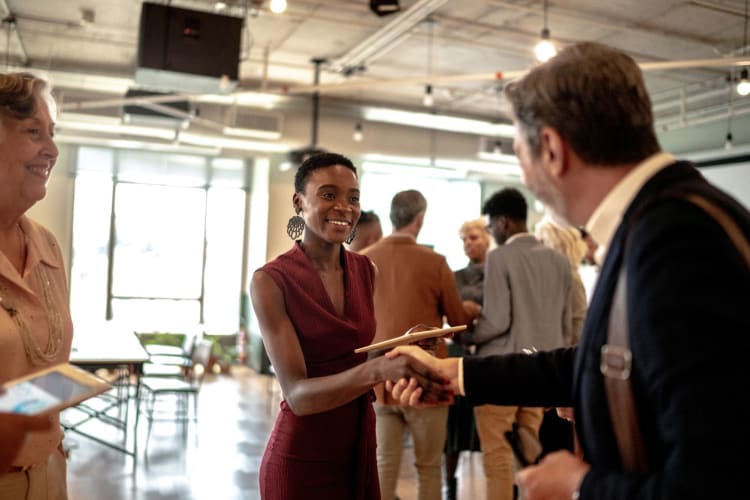 two business people shaking hands at an event