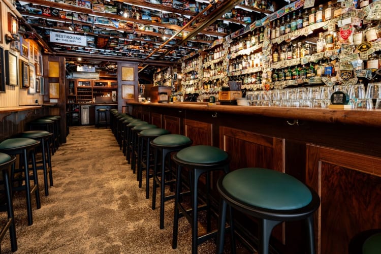 a bar lined with green stools