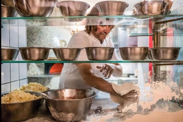 Italian pizza maker creating dough