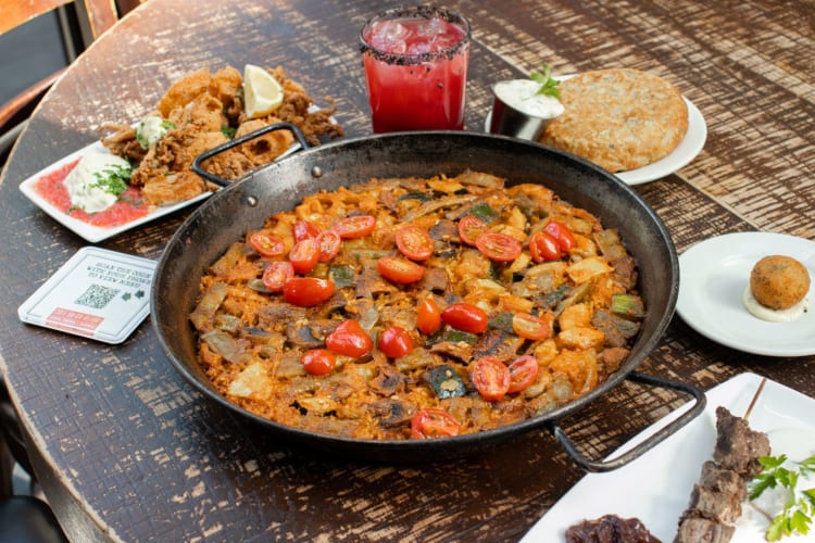 a large dish of paella on an outdoor table