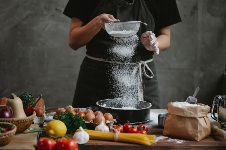 eggs sitting out while chef sifts flour