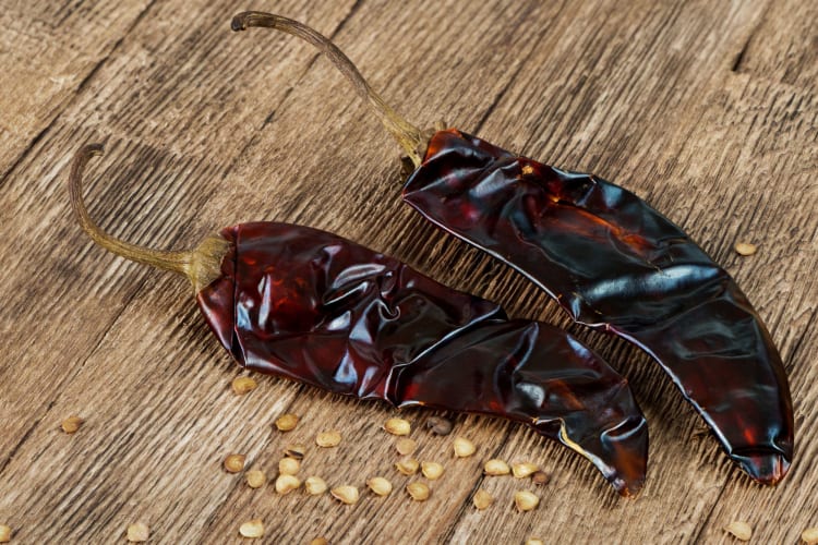 guajillo peppers with seeds on wooden table