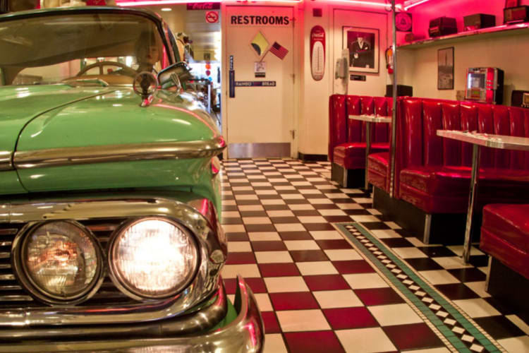 50s-style diner interior with checkered floor and green vintage car