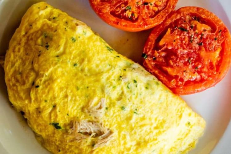 a large omelette and grilled tomatoes