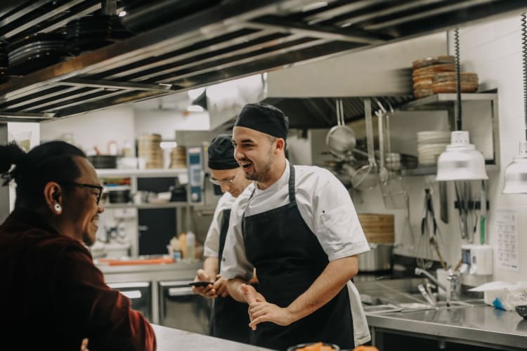 chefs laughing together in kitchen