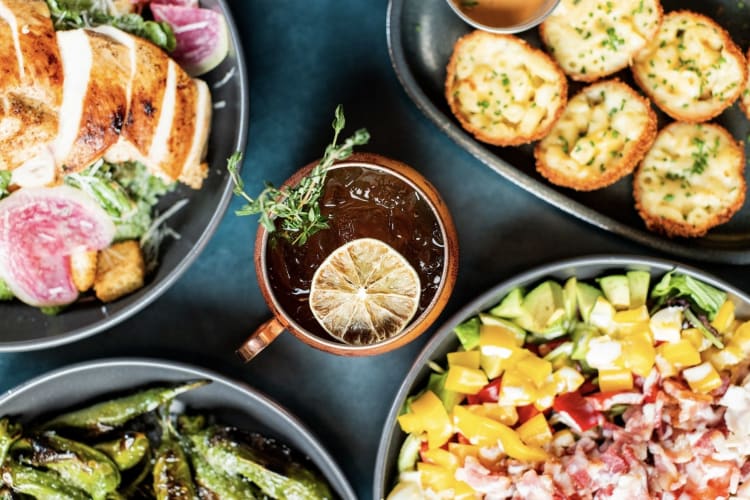 shishito peppers, salad and other appetizers with a drink