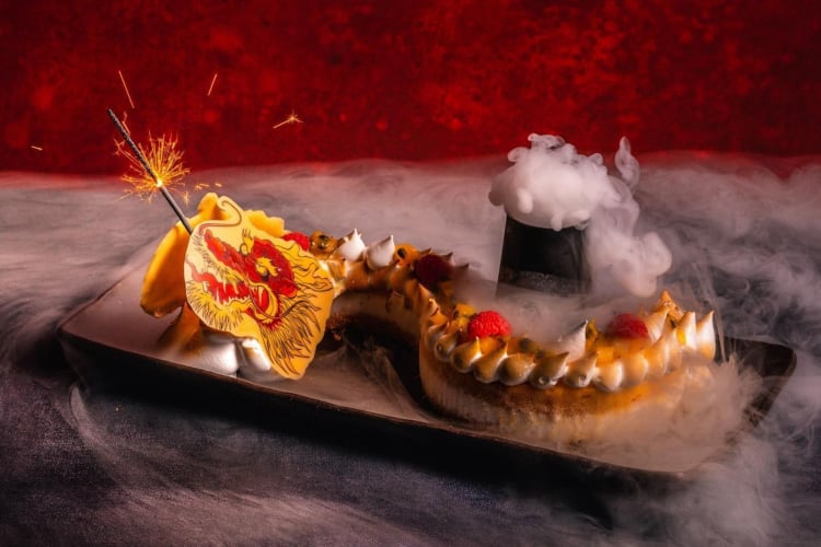 an elaborate sushi roll with dry ice shaped like a dragon