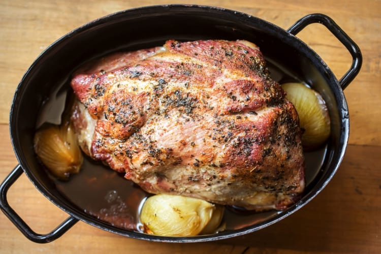 pork shoulder in roasting pan with vegetables