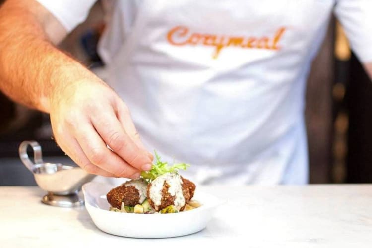 a chef garnishing a dish of vegetarian falafel