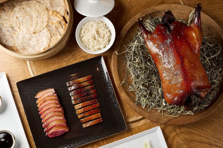 Peking duck and sides arranged on a table