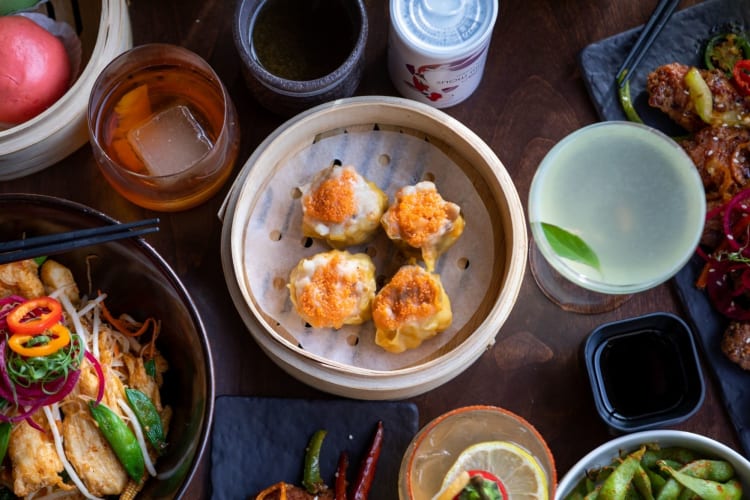 a table of dim sum, noodles and drinks