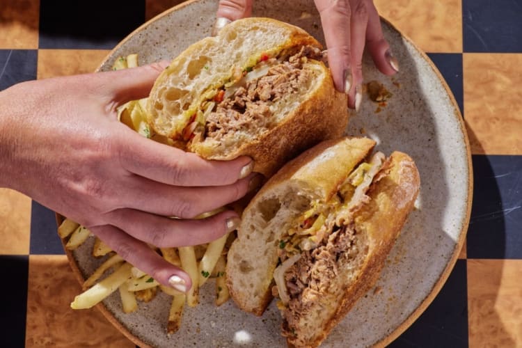 female hands holding braised beef brisket sandwich