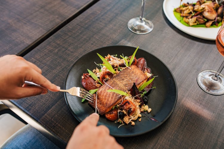 man cutting into salmon