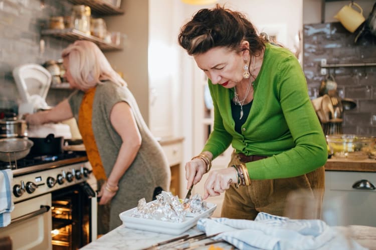 a woman checking the doneness of her salmon in foil