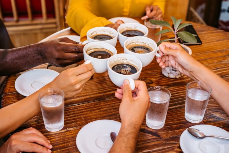 five friends clinking coffee glasses together