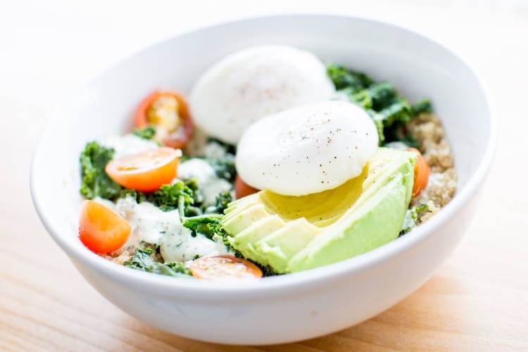 poached eggs on greens with avocado