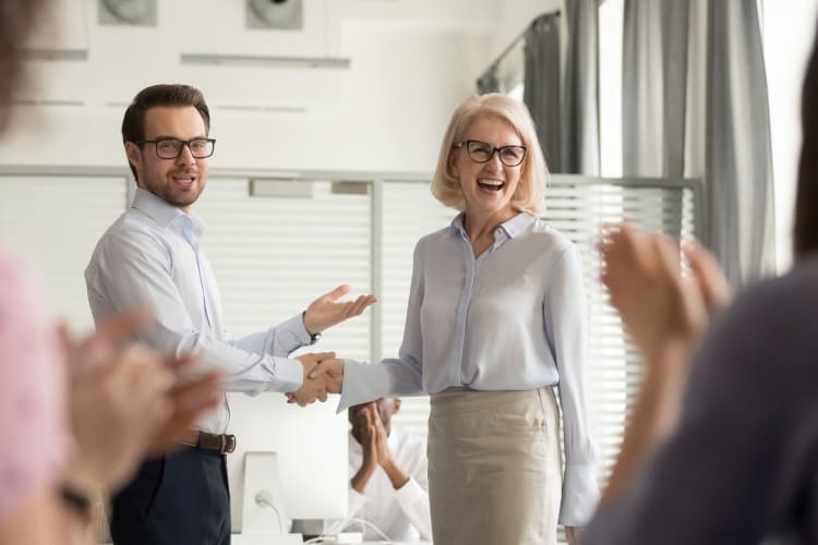 senior female employee being recognized in front of peers