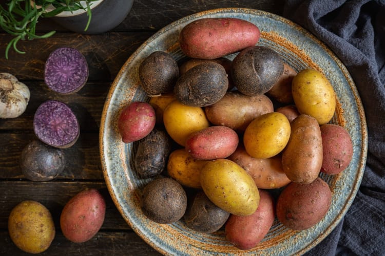 a variety of potato types in a blue bowl