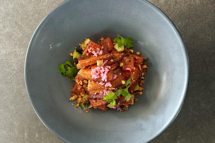 seared pork belly on a bed of fruits and vegetables