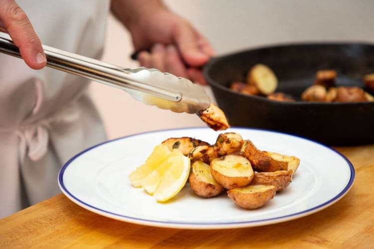 a chef plating potatoes