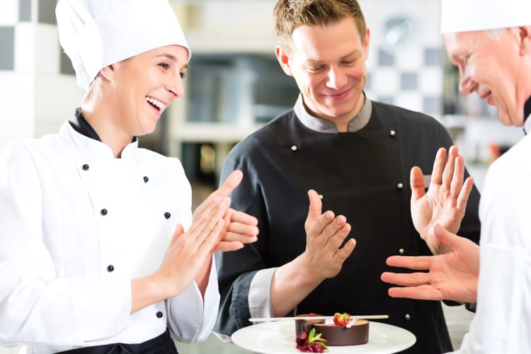 chefs applauding a colleague's beautiful dessert creation