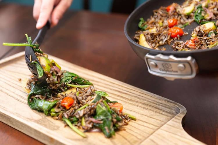 chef plating a dish of rice and vegetables