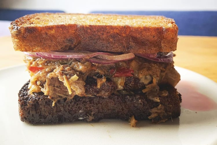 a patty melt on a white plate