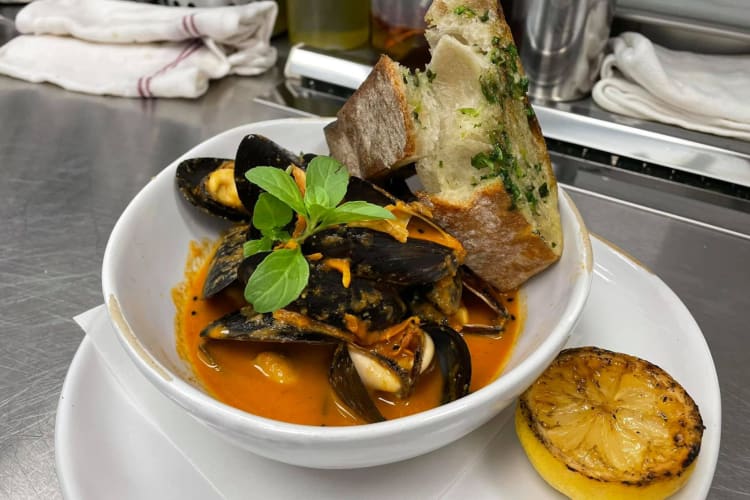 Seafood dish with sauce and bread from Da Gama, an Indian-Portuguese restaurant in Houston.