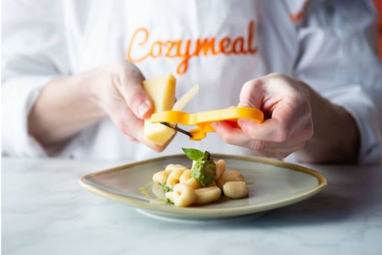 a chef garnishing a dish of pasta