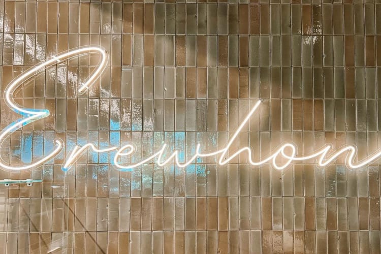 Erewhon in lit-up cursive on a shiny wall