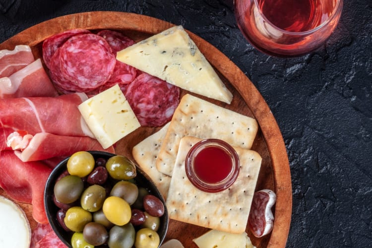 olives on a charcuterie board with cheese and crackers