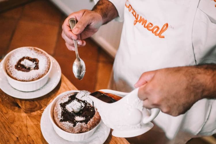 a chef pouring chocolate onto a souffle