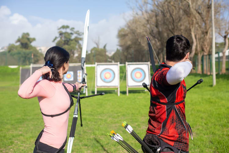 two young people practicing archery