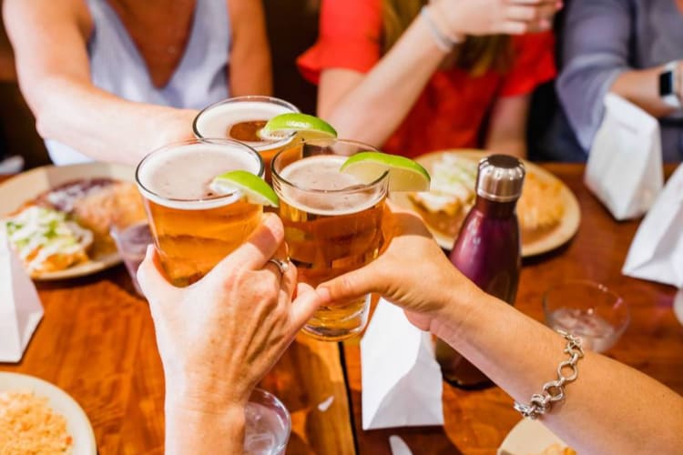 people on a food tour clinking beer glasses