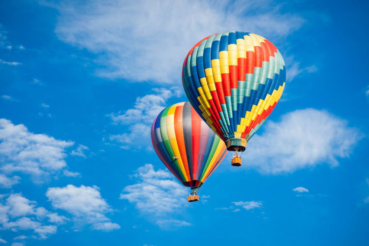 two hot air balloons against a blue sky