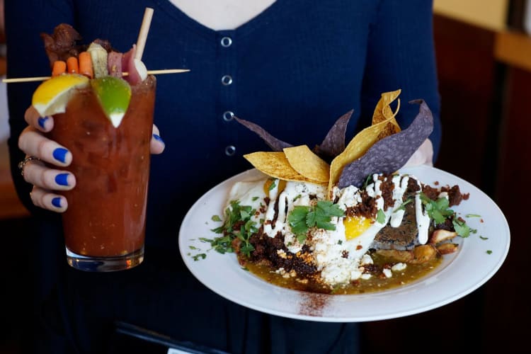 woman holding bloody mary and salad