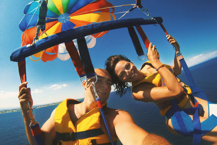 man and woman parasailing over water