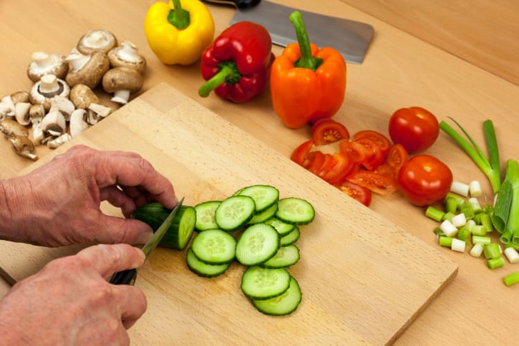 slicing English cucumbers on a cutting board