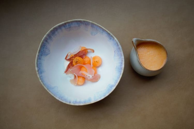 an artfully plated dish against a muted gray background