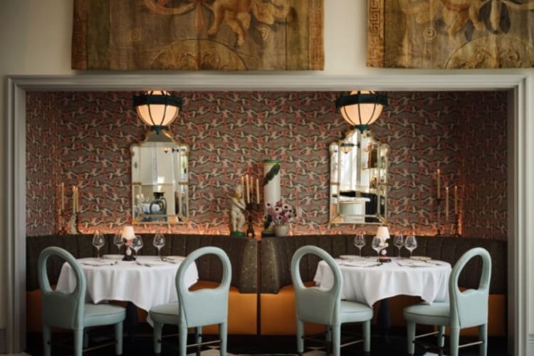 an ornate restaurant dining room with classical tapestries on walls