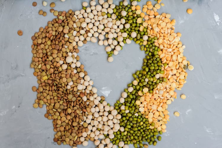 dried beans forming a heart shape on gray background