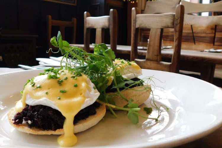 poached eggs, blood pudding, sauce and a muffin