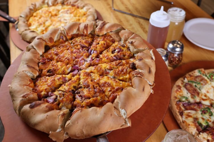 a large mountain-style pizza with thick rolled crust