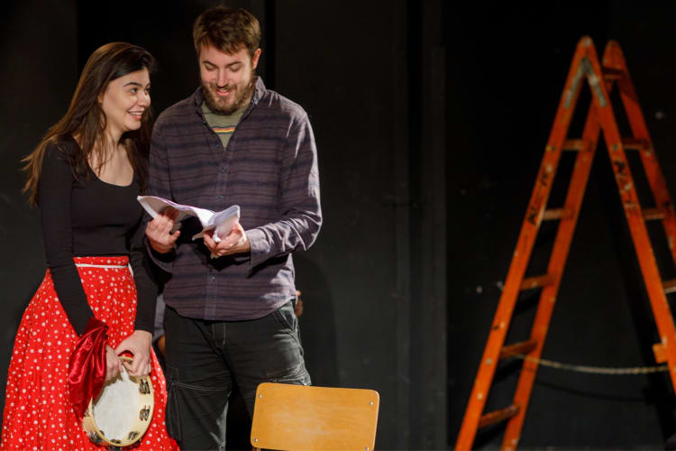 a man and woman onstage performing improv together